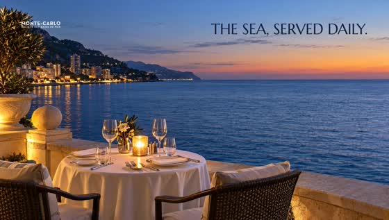A candlelit table for two on a terrace over the open sea
